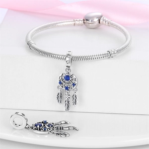 Detail of silver dreamcatcher charm with blue stone and feathers on snake chain bracelet
