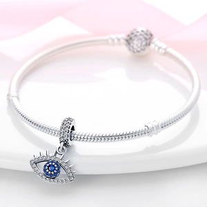 Primer plano de pulsera de plata con dije de ojo turco azul y circonitas blancas brillantes