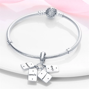 Detail eines silbernen Schlangenarmbandes mit Poker-Anhängern und Pavé-Verschluss