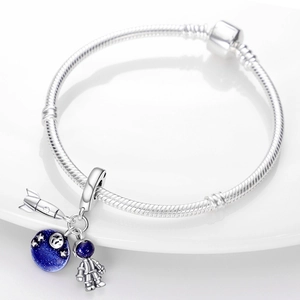 Detailansicht vom Silberarmband mit Anhängern aus Rakete, Astronaut und blauem Planeten