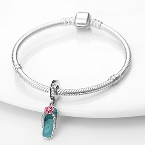 Details des silbernen Schlangenarmbands mit blauem Emaille-Flip-Flop und rosa Blume