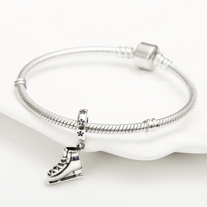 Silbernes Schlangenarmband mit detailliertem Schlittschuh-Anhänger und blauen Steinen