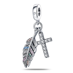 Détail d'une breloque en argent avec plume multicolore et pendentif croix en zircon