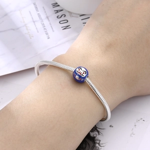 Dettaglio del charm Daruma con carattere Fu su un bracciale a catena d'argento