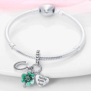 Gros plan détaillé du bracelet maille serpent en argent avec trèfle et fer à cheval