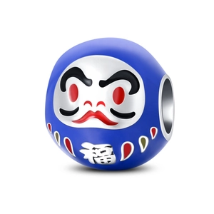 Dettaglio macro del ciondolo Daruma blu scuro con carattere bianco 福 e dettagli rossi