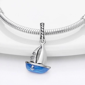 Makro-Detail des Segelboot-Anhängers mit blauer Emaille und Kristallen am Armband