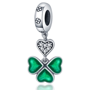 Détail de breloque trèfle en argent avec émail vert et pendentif cœur serti de zircons