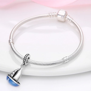 Makroaufnahme eines silbernen Jacht-Anhängers mit blauer Emaille auf einem Schlangenarmband