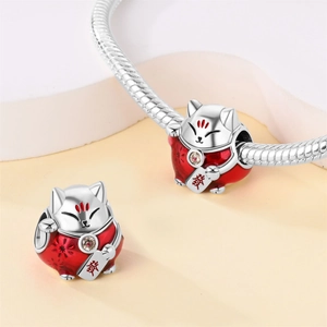 Dettaglio macro dello charm gatto portafortuna in smalto rosso con catena a serpente