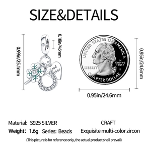 Vue détaillée de la taille du pendentif trèfle à côté d'une pièce de 25 cents pour échelle
