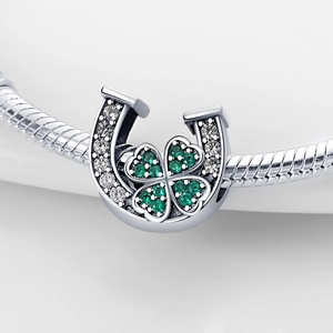 Détail macro du charm fer à cheval et trèfle vert avec des pierres de zircon brillantes
