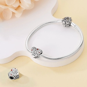 Macro view of silver heart charms with LOVE engraving on snake chain bracelet
