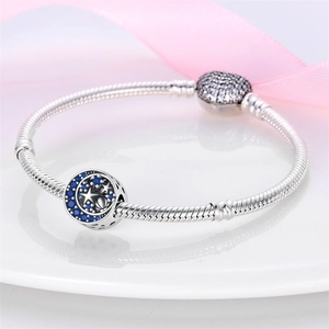 Primer plano de pulsera de cadena de serpiente con dije de luna estrella y circón