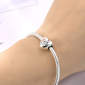 Detail of silver heart charm with family engraving and handwriting font on snake chain