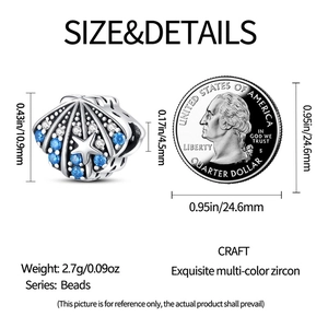 Abalorio de concha plateada con circonitas azules junto a moneda para escala