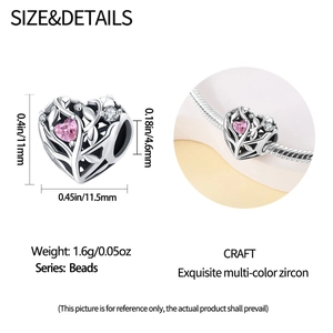 Macro detail of hollow heart charm bead with pink zircon inlay and intricate vine patterns