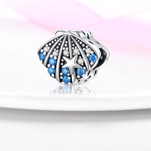 Primer plano de charm de concha de plata con circonitas azules y detalle de estrella