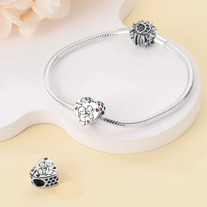 Detail of silver charm bracelet featuring heart-shaped beads with BEST MOM engraving