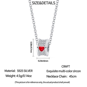 Detailed view of S925 silver cylinder pendant with white zircons and red heart