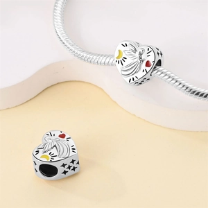 Detailed view of silver heart beads with fairy and moon charms on a snake chain