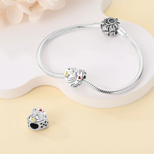 Detailed close-up of a silver heart-shaped charm bracelet with a sun and moon clasp