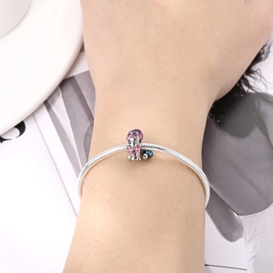 Detail of silver snake chain bracelet featuring a purple zircon unicorn charm on wrist