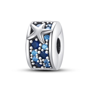 Primer plano detallado de un charm plateado con cristales azules y motivos de estrella