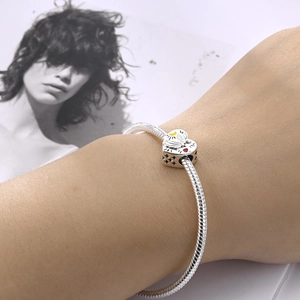Detailed view of silver heart charm with moon motif and star cutouts on snake chain