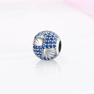 Primer plano de dije de concha de plata con cristales azules para pulseras