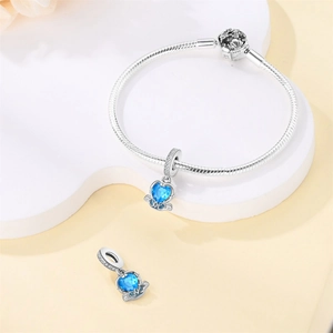Detail of silver snake chain bracelet with hollow pumpkin carriage charms and blue gems
