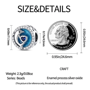 Detalle macro del dije delfín de plata con corazón de circón azul junto a moneda