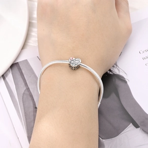 Primer plano del colgante de corazón con pareja animada en pulsera de plata