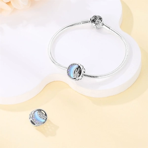 Detailed macro view of fairytale castle charm on a silver snake chain bracelet