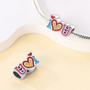 Detailed macro view of multi-color enamel I Heart U charm bead on a silver bracelet