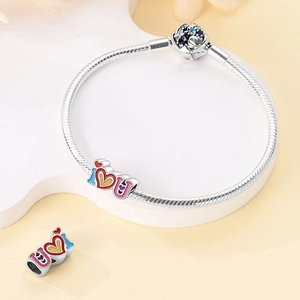 Detail of silver snake chain bracelet featuring I Love You enamel charms and zircon floral clasp