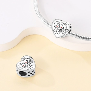 Detailed view of silver heart charm featuring a wedding couple illustration and hollow sides