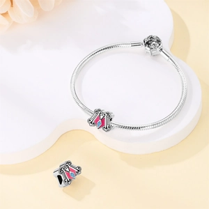 Detail of S925 sterling silver snake chain bracelet with enamel castle and unicorn charms
