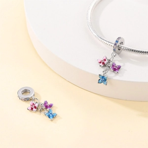 Macro shot of colorful floral enamel charms with zircons on a silver-plated bracelet