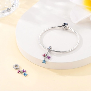 Detailed view of colorful enamel butterfly charms on a silver-plated snake chain bracelet.