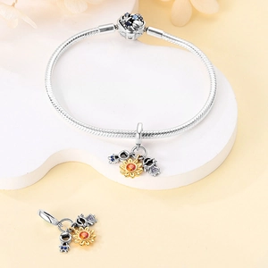 Detail of S925 silver charm bracelet with sunflower and boy-girl pendants on white stand