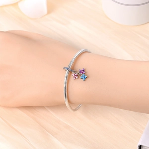 Silver charm bracelet with colorful enamel floral daisy pendants on a snake chain