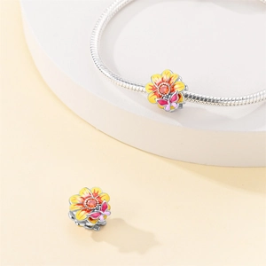 Macro detail of 925 silver flower charm with gradient petals and a pink butterfly