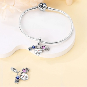 Macro detail of 925 silver plated bracelet with Yes I Do heart charm and zircon stones