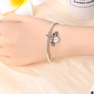Detail of silver snake chain bracelet featuring heart charm with 'Yes I Do' engraving
