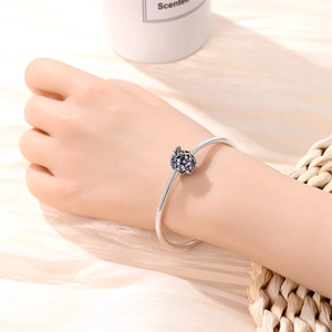 Silver snake chain bracelet with floral butterfly charm featuring purple enamel details