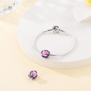 Detail of silver snake chain bracelet with purple enamel pansy flower charms and zircon