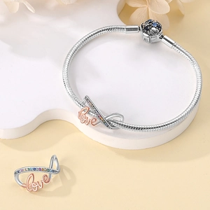 Macro detail of S925 silver snake chain bracelet with rose gold love pendant and zircon