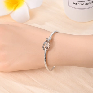 Silver snake chain bracelet with rose gold Love charm and infinity symbol on wrist