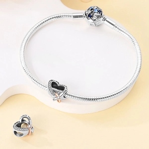 Detail of silver snake chain bracelet with sparkling I Love You heart and blue starry charm